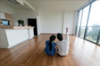 Couple sitting on floor looking at a wall with large window view
